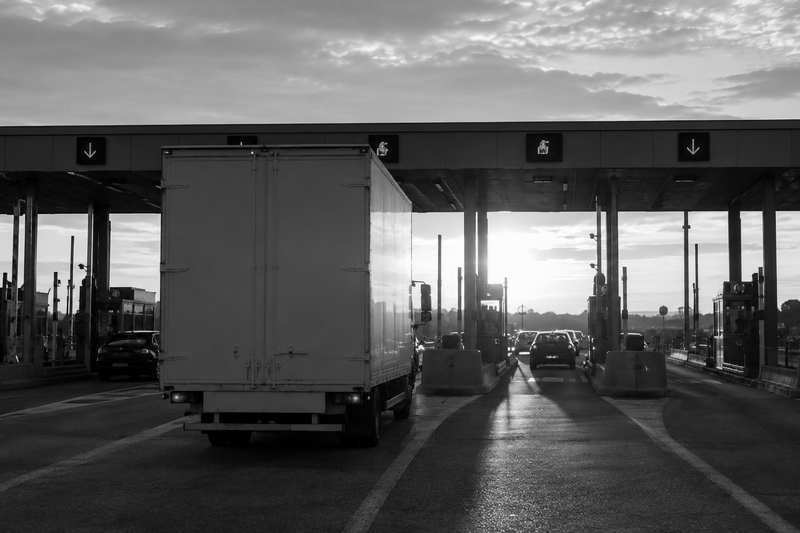 Camion de transport de piano engagé sous l’auvent d’un péage autoroutier