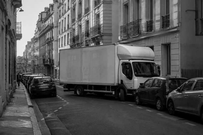 Camion de déménagement en manœuvre de recul dans une rue parisienne étroite