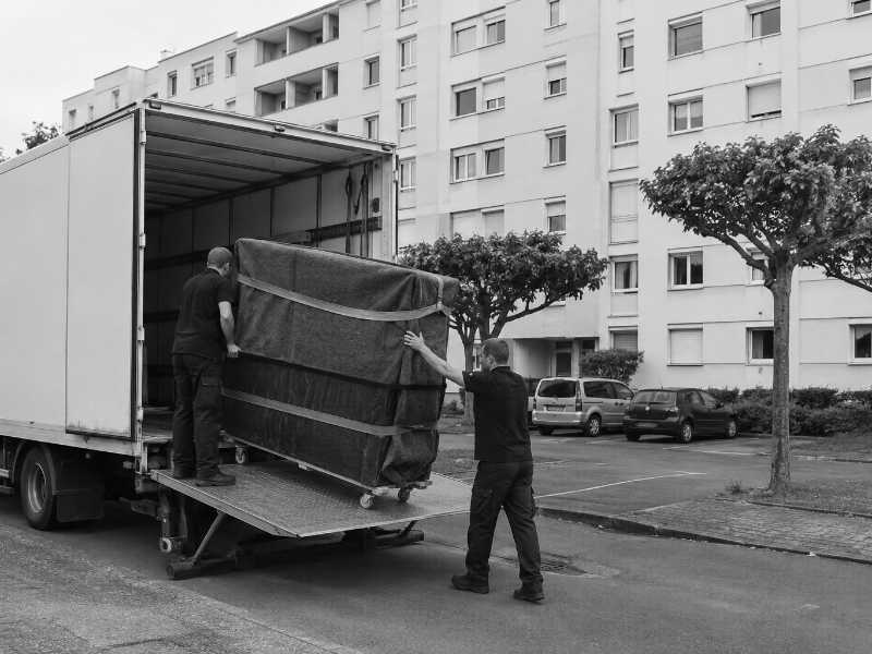 Chargement d’un piano droit emballé par hayon élévateur à Châtillon (92), devant une barre d’immeubles