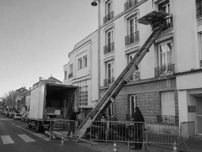 Monte-meuble installé contre un immeuble à Garches (92), cheminement piéton balisé