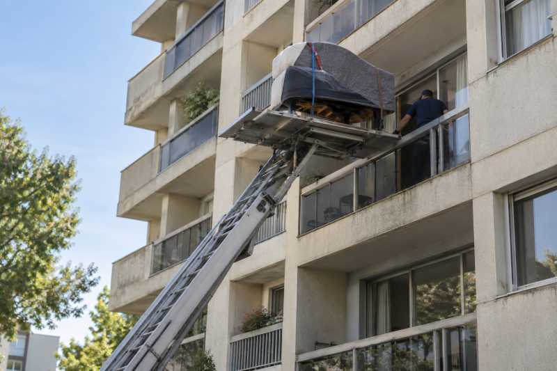 Piano quart-de-queue emballé sur le plateau d'un monte-meubles au cinquième étage d'une résidence, Villeneuve-le-Roi
