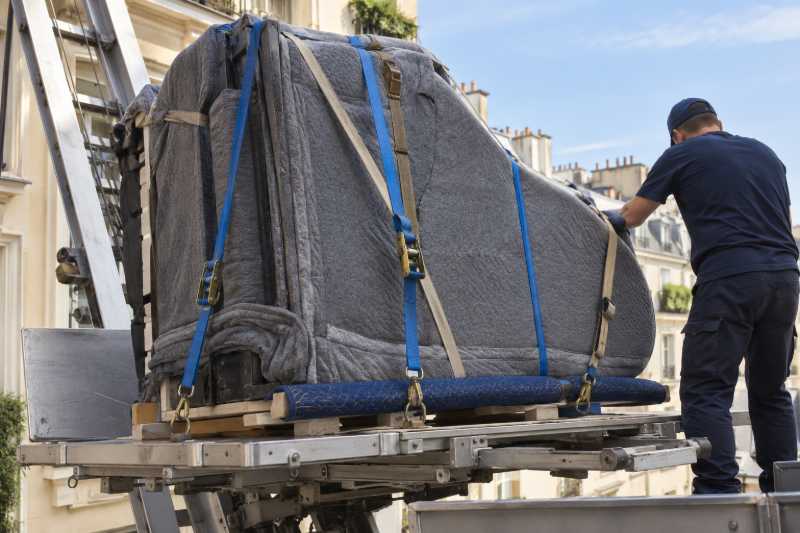 Piano à queue couché sur luge, sanglé sur le plateau d'un monte-meubles, Lognes