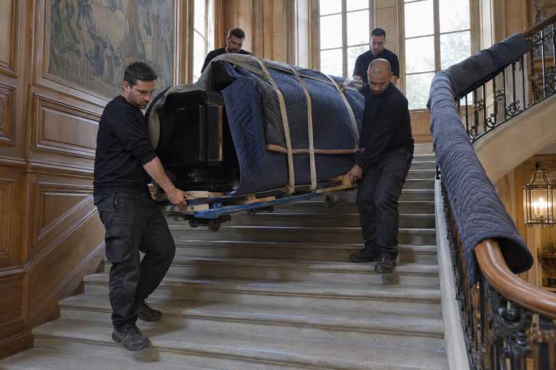 Quatre déménageurs descendant un piano à queue sur luge dans un grand escalier ancien, Montreuil