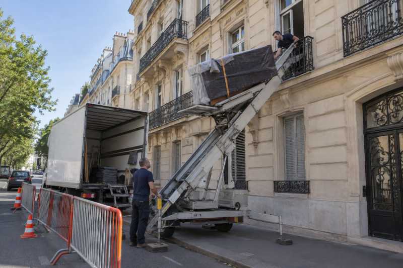 Monte-meubles hissant un piano droit emballé dans une rue en travaux, Villetaneuse