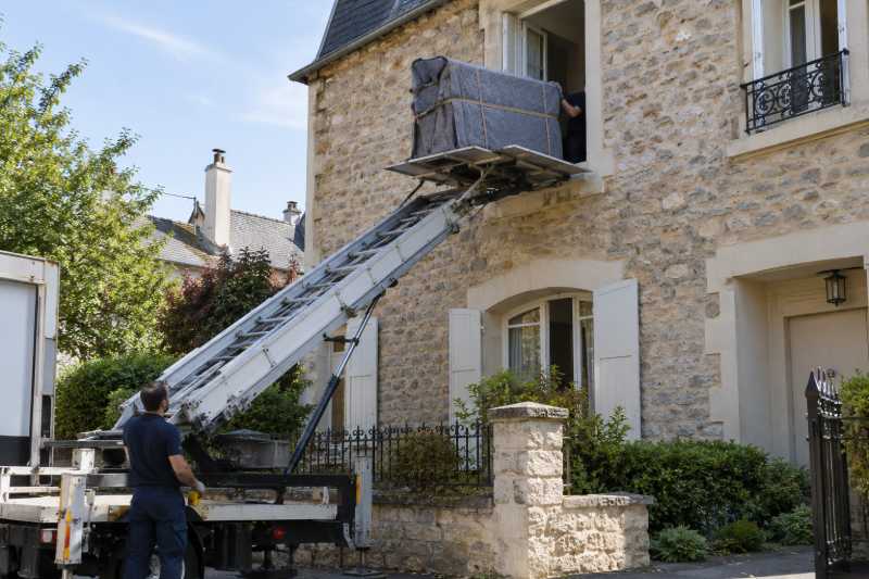 Piano droit emballé monté au monte-meubles vers la fenêtre d'une maison en pierre, Gretz-Armainvilliers