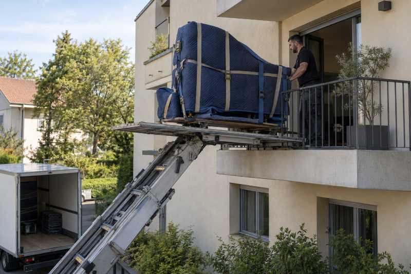 Piano quart-de-queue emballé soulevé depuis un balcon par une plateforme élévatrice, Évry-Courcouronnes