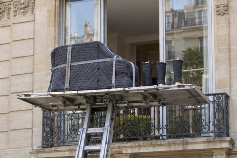 Caisse de piano à queue sur monte-meuble devant une baie, Saint-Denis